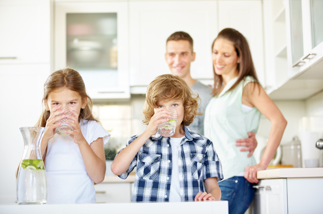 Family drinking clean water in modern kitchen